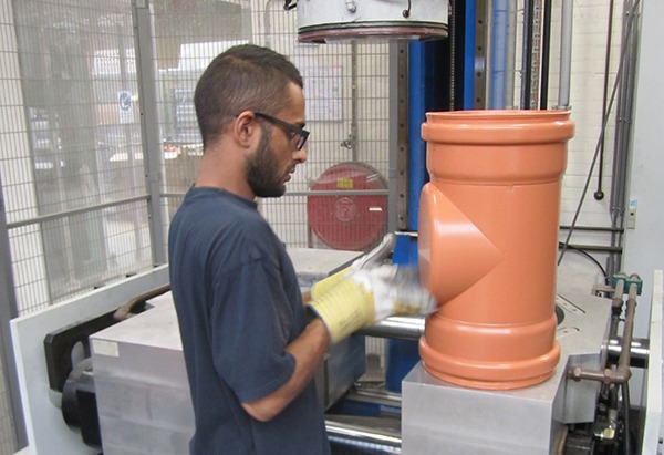 Productiemedewerker met rioleringshulpstuk Productiemedewerker met rioleringshulpstuk